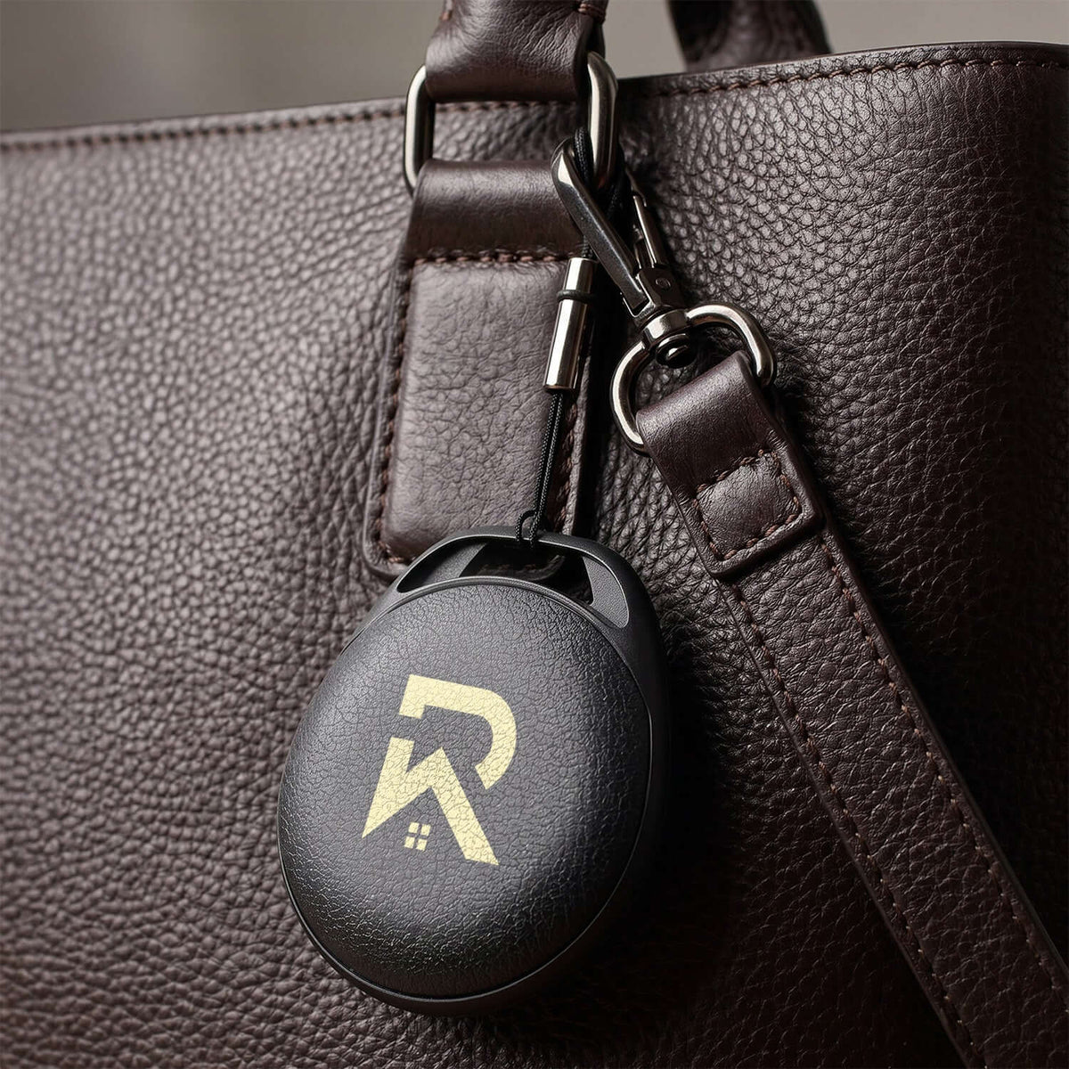 HangFindy Bluetooth Tracker attached to a stylish brown bag, serving as a practical corporate gift.