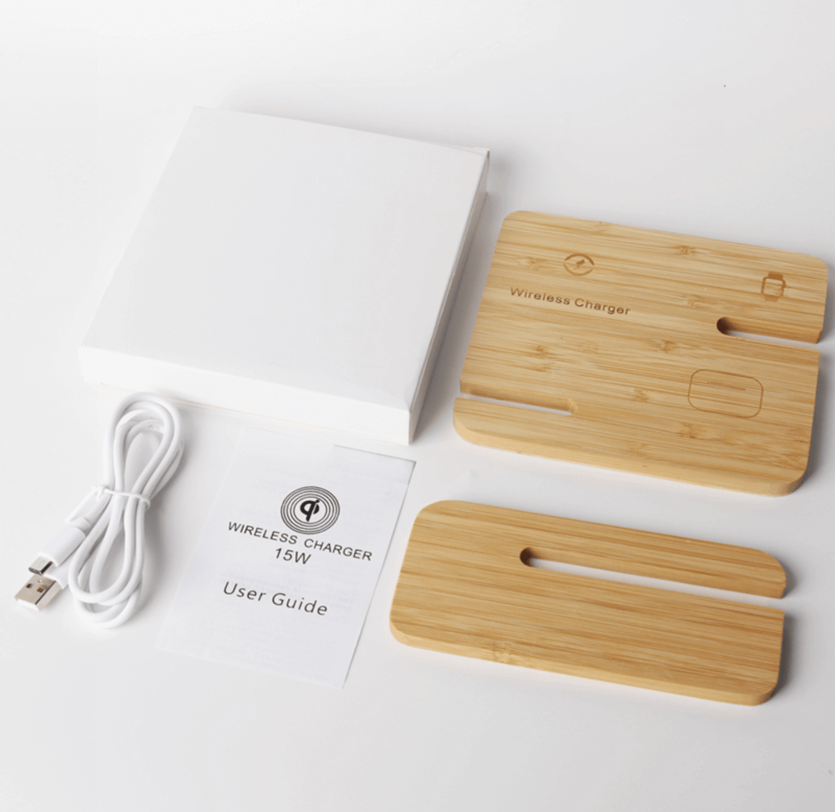 Bamboo charging panel and slotted support beside a white box, coiled USB cable and user guide marked Wireless Charger 15W