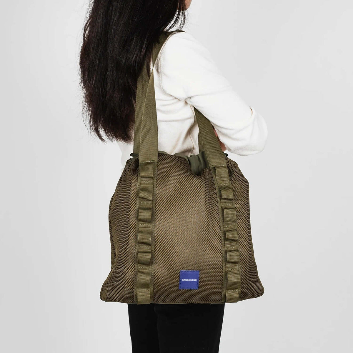 Crossing Noa Drawstring Mesh Tote Bag shown in use, featuring a stylish design and durable mesh construction.