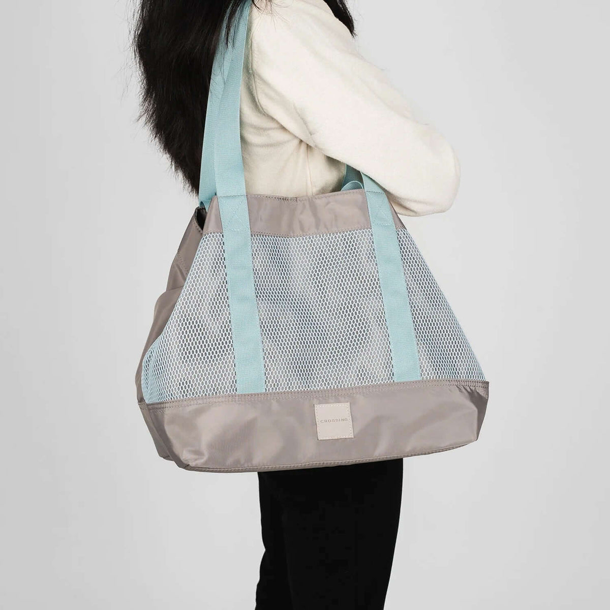 Crossing Meg Dual Carry Mesh Tote Bag being held by a woman, showcasing its stylish mesh design and dual handles.