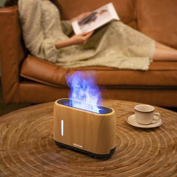 Prixton Essence humidifier with flame effect on a wooden table in a cozy living room