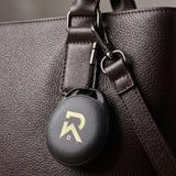 HangFindy Bluetooth Tracker attached to a stylish brown bag, serving as a practical corporate gift.