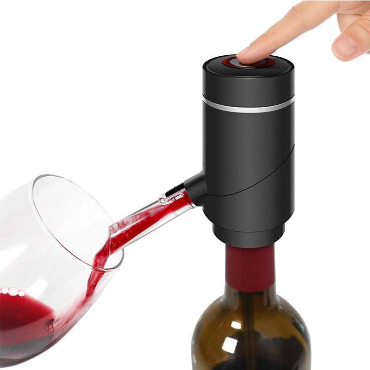 Black electric wine aerator mounted on a bottle, with a finger pressing the top button as wine pours into a glass