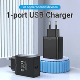 Vention 1-Port USB Wall Charger 12W on a table, ideal for charging Apple and Android devices efficiently.