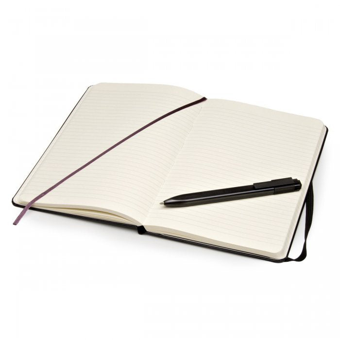 Open Moleskine ruled notebook with ribbon bookmark and black roller pen across the pages