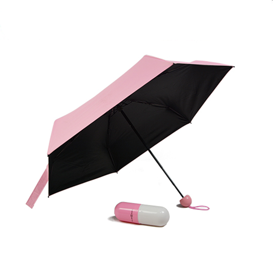 Pink capsule mini folding umbrella with black underside, wrist loop and pink-and-white capsule case