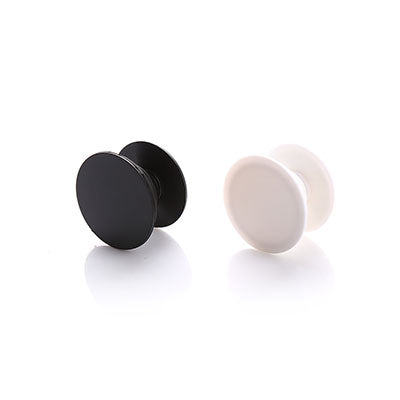 Black and pale-coloured round collapsible phone grips pictured with circular faces and extended rear bases