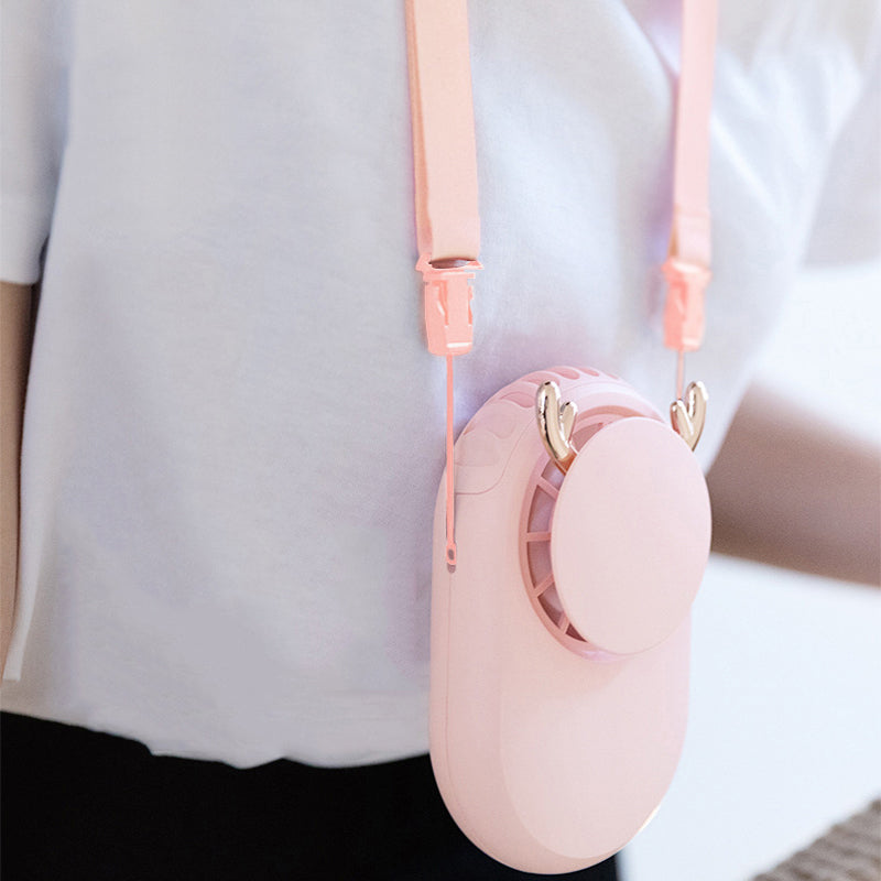 Pink rechargeable personal fan hanging from a neck strap against a white shirt