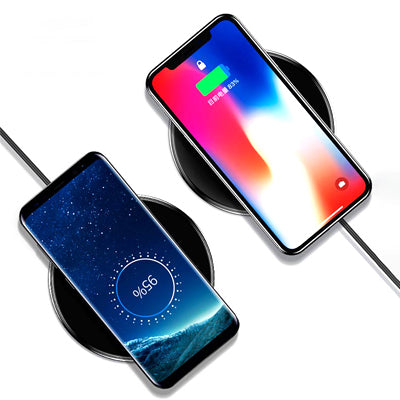 Two phones placed on separate powered wireless charging pads