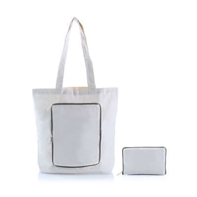 Light-coloured canvas zipper foldable tote with a grey-trimmed front panel, shown open beside its compact folded pouch