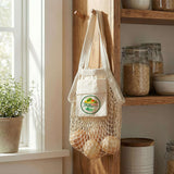 Cotton Mesh Foldaway Tote Bag - Small hanging in a kitchen with fresh fruit and a small cotton pocket.