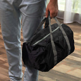Person holding an Origami Foldable Duffle Bag with durable handles, perfect for travel and gifts in Singapore.