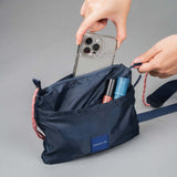 Crossing Kai Crossbody Bag open showing phone and cosmetics in interior pockets, ideal as a corporate gift.