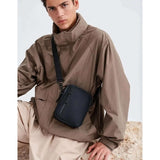 Model wearing Gaston Luga Dash Verti Crossbody bag, showcasing its stylish design and eco-friendly material.