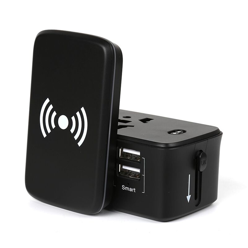 Detached wireless charging pad standing beside the black travel adaptor, exposing the top multi-format socket and two USB-A ports