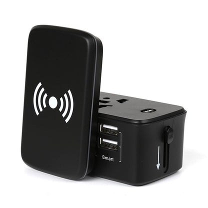 Detached wireless charging pad standing beside the black travel adaptor, exposing the top multi-format socket and two USB-A ports