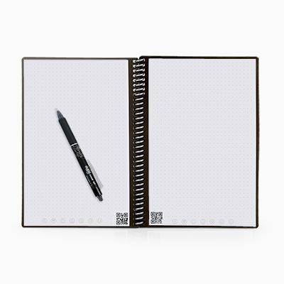 Open spiral-bound Rocketbook notebook showing dot-grid pages, lower scan codes and destination symbols, with a black pen